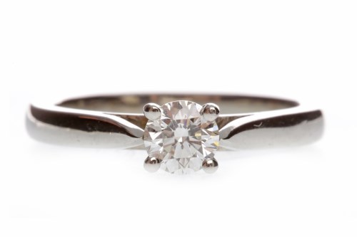Lot 638 - PLATINUM DIAMOND SOLITAIRE RING with a four...