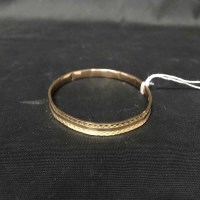 Lot 413 - NINE CARAT GOLD BANGLE with engraved decoration