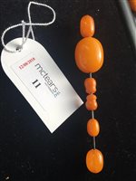 Lot 11 - TWO AMBER BEAD NECKLACES ALONG WITH A BRACELET AND A HAT PIN