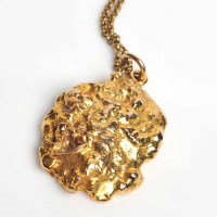 Lot 1747 - NINE CARAT GOLD NUGGET MOTIF PENDANT on an...