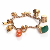 Lot 1803 - NINE CARAT GOLD CHARM BRACELET with charms...