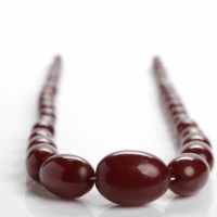 Lot 28 - CHERRY BAKELITE NECKLACE formed by graduated...