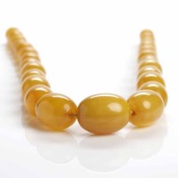 Lot 55 - GRADUATED AMBER BEAD NECKLACE formed by ovoid...