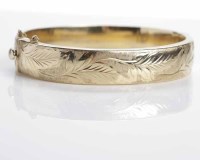 Lot 201 - NINE CARAT GOLD HINGED BANGLE of oval form,...