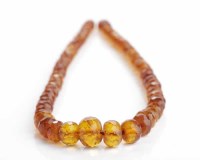 Lot 215 - GRADUATED AMBER BEAD NECKLACE with faceted...
