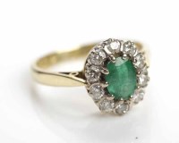 Lot 216 - EMERALD AND DIAMOND CLUSTER RING set centrally...