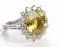 Lot 319 - YELLOW SAPPHIRE AND DIAMOND CLUSTER RING the...