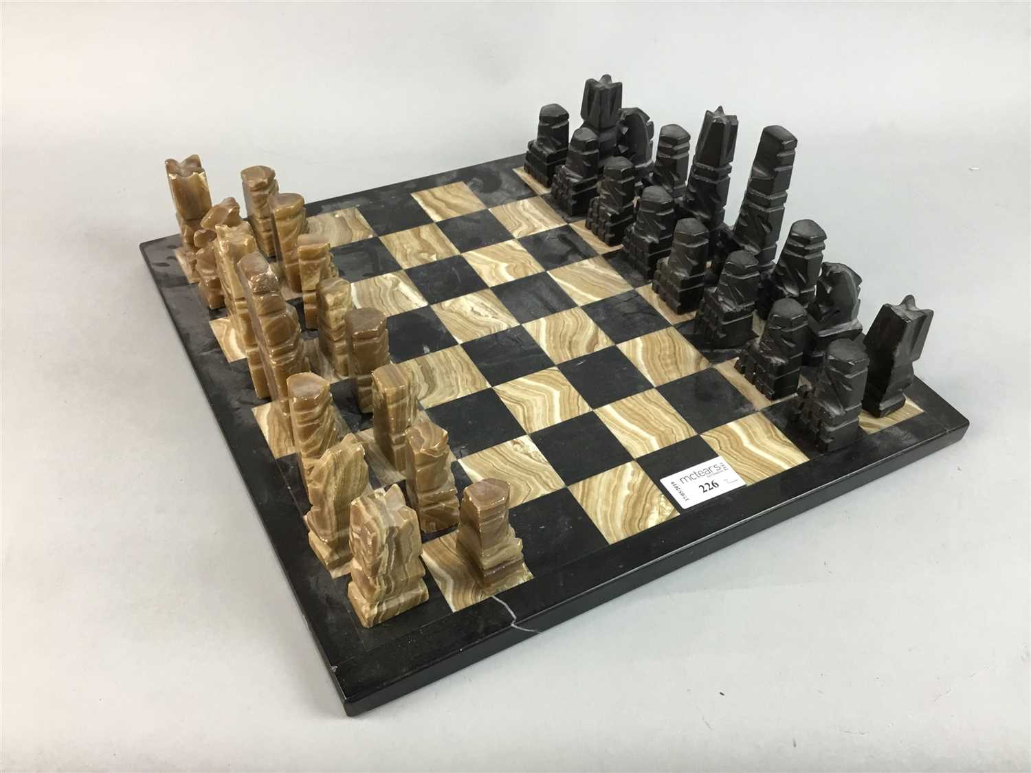 Lot 226 - AN ONYX CHESSBOARD AND A MARBLE CHESSBOARD WITH GAMING PIECES