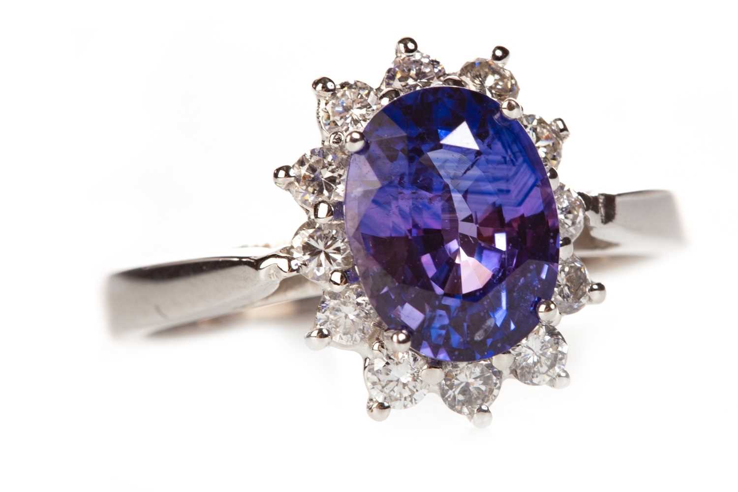 Lot 207 - A PURPLE SAPPHIRE AND DIAMOND CLUSTER RING