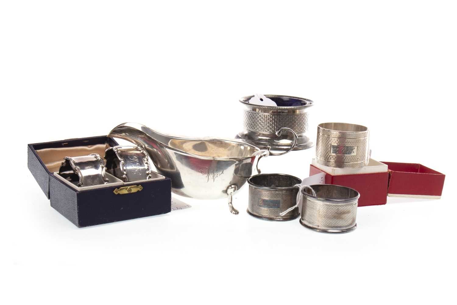 Lot 887 - A LOT OF FIVE SILVER NAPKIN RINGS AND AN IRISH SILVER SAUCE BOAT