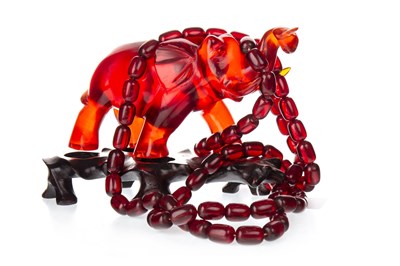 Lot 1199 - A CHERRY AMBER BEAD NECKLACE AND AN ELEPHANT