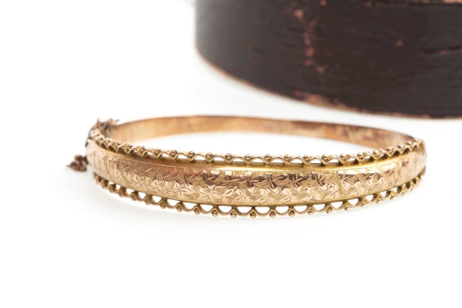 Lot 12 - A NINE CARAT GOLD BANGLE WITH CHARM AND RING