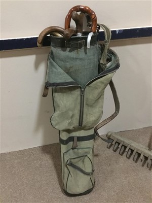 Lot 165 - A VINTAGE GOLF BAG WITH WALKING STICKS AND TWO HAY RAKES