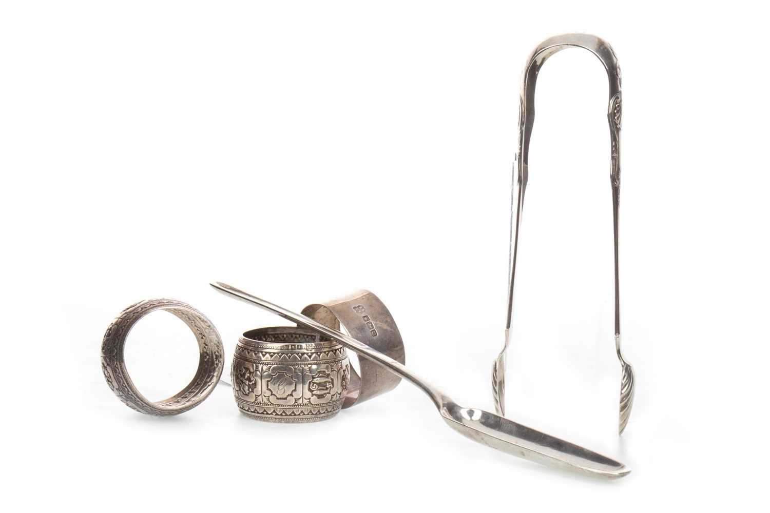Lot 830 - A GEORGE III SILVER MARROW SCOOP ALONG WITH THREE NAPKIN RINGS AND A PAIR OF SUGAR TONGS