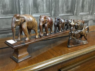 Lot 405 - AN AFRICAN CARVING OF A GROUP OF ELEPHANTS AND ANOTHER FIGURE GROUP