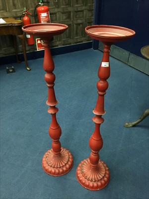 Lot 485 - A PAIR OF RED PAINTED COMPOSITE TORCHERES