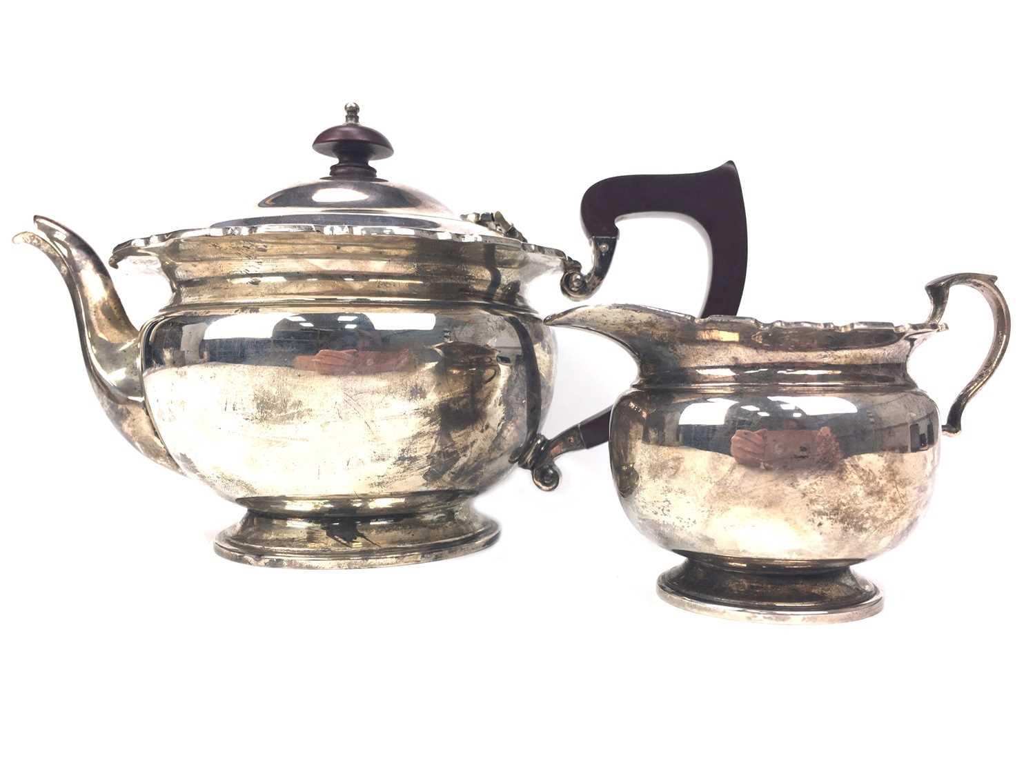 Lot 424 - AN EARLY 20TH CENTURY SILVER TEAPOT AND CREAMER