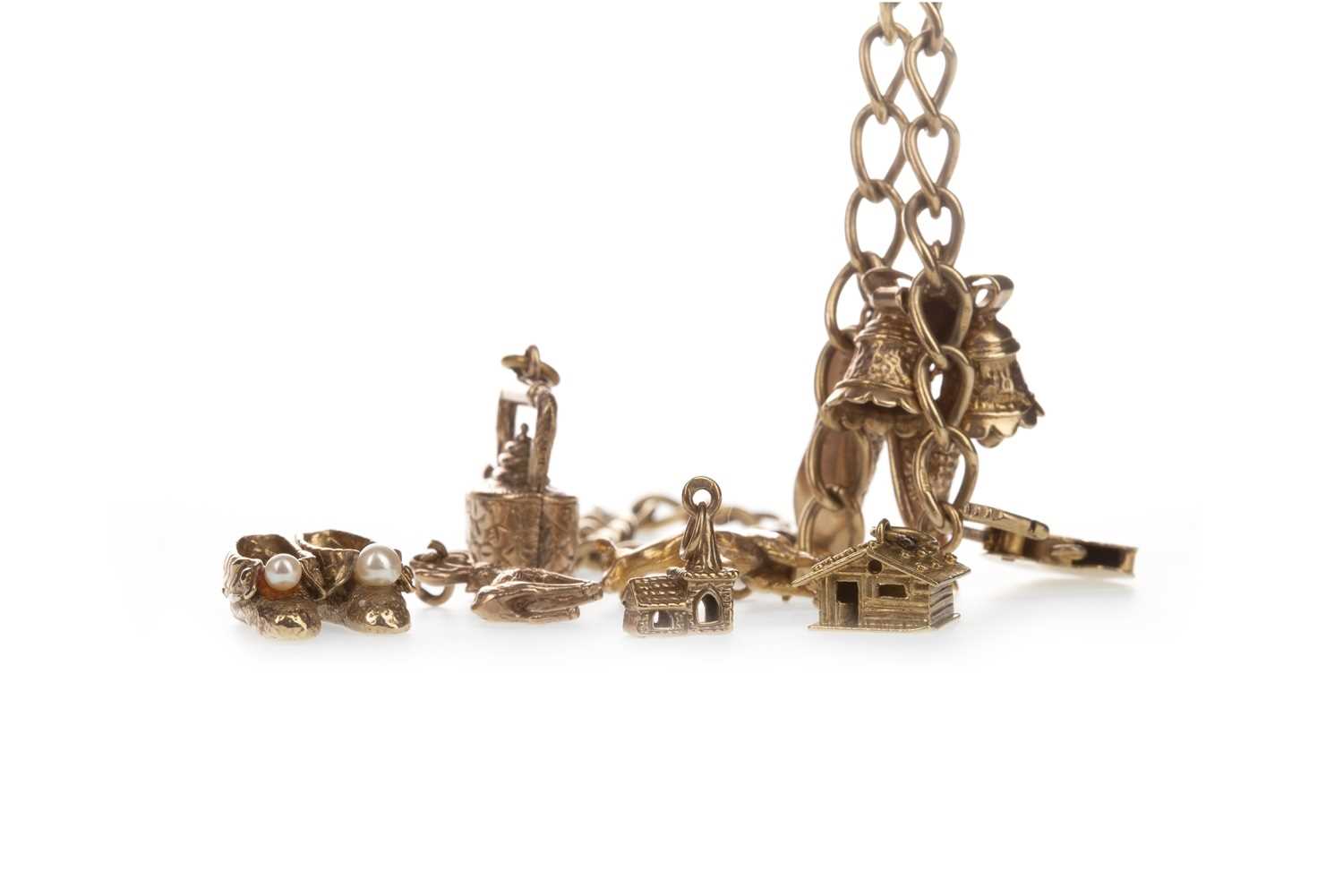 Lot 309 - A GOLD CHARM BRACELET ALONG WITH LOOSE CHARMS