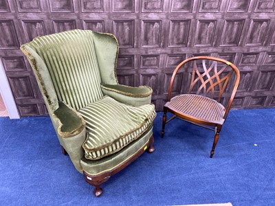 Lot 251 - A 20TH CENTURY UPHOLSTERED WING BACKED ARMCHAIR AND A CANE PANELLED ARMCHAIR