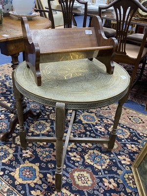 Lot 457 - A CIRCULAR BRASS TOPPED TABLE WITH FOLDING BASE AND A MAHOGANY BOOK TROUGH