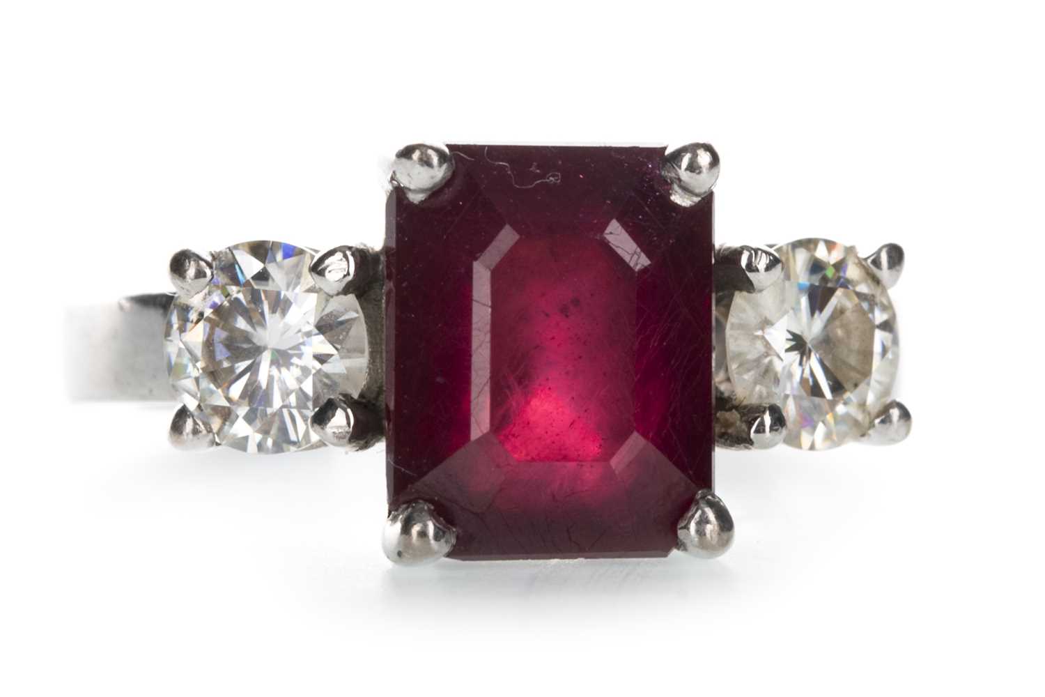 Lot 1391 - A RED GEM SET AND MOISSANITE THREE STONE RING