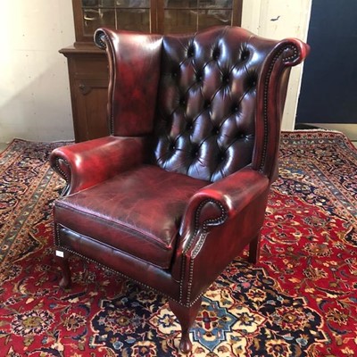 Lot 48 - A WING BACK ARMCHAIR IN OXBLOOD LEATHER