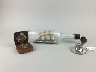 Lot 103 - AN EARLY 20TH CENTURY SILVER INKWELL, A SHIP IN A BOTTLE AND A COMPASS