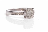 Lot 122 - DIAMOND CLUSTER RING set with four central...