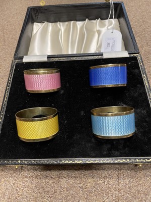 Lot 502 - A SET OF SILVER AND ENAMEL NAPKIN RINGS AND COFFEE SPOONS