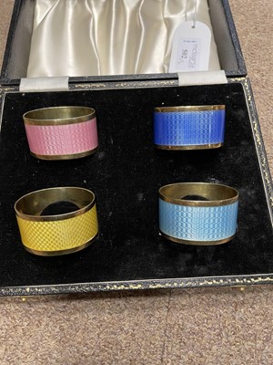 Lot 502 - A SET OF SILVER AND ENAMEL NAPKIN RINGS AND COFFEE SPOONS