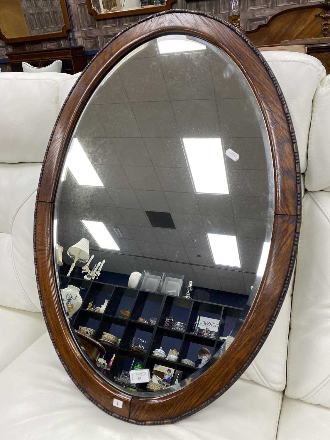 Lot 84 - AN OVAL BEVELLED WALL MIRROR