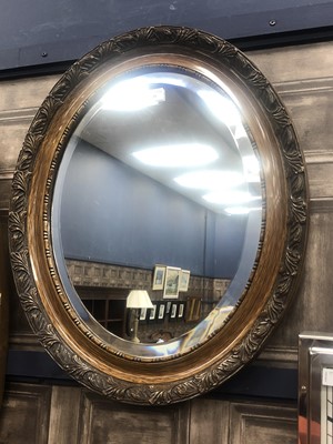 Lot 135 - AN OVAL STAINED WOOD WALL MIRROR