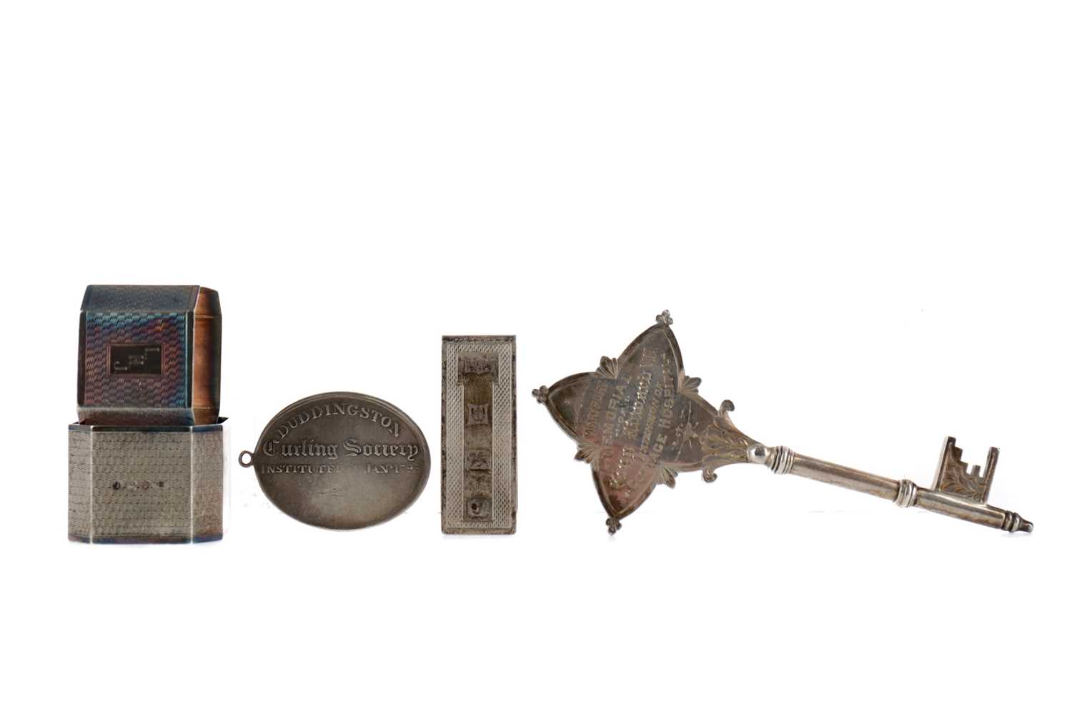 Lot 475 - A GEORGE V SILVER PRESENTATION KEY, ALONG WITH TWO NAPKIN RINGS A MONEY CLIP AND A MEDAL