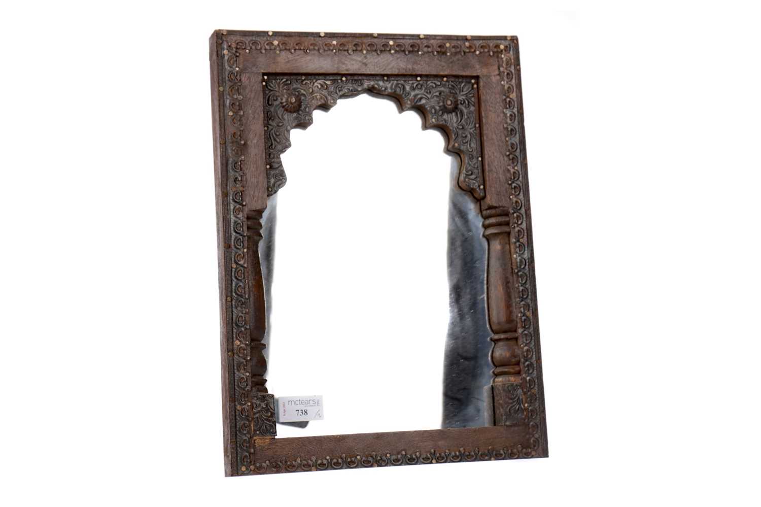 Lot 738 - A MOORISH CARVED WOOD FRAMED MIRROR AND A PLATED FLORAL PLAQUE
