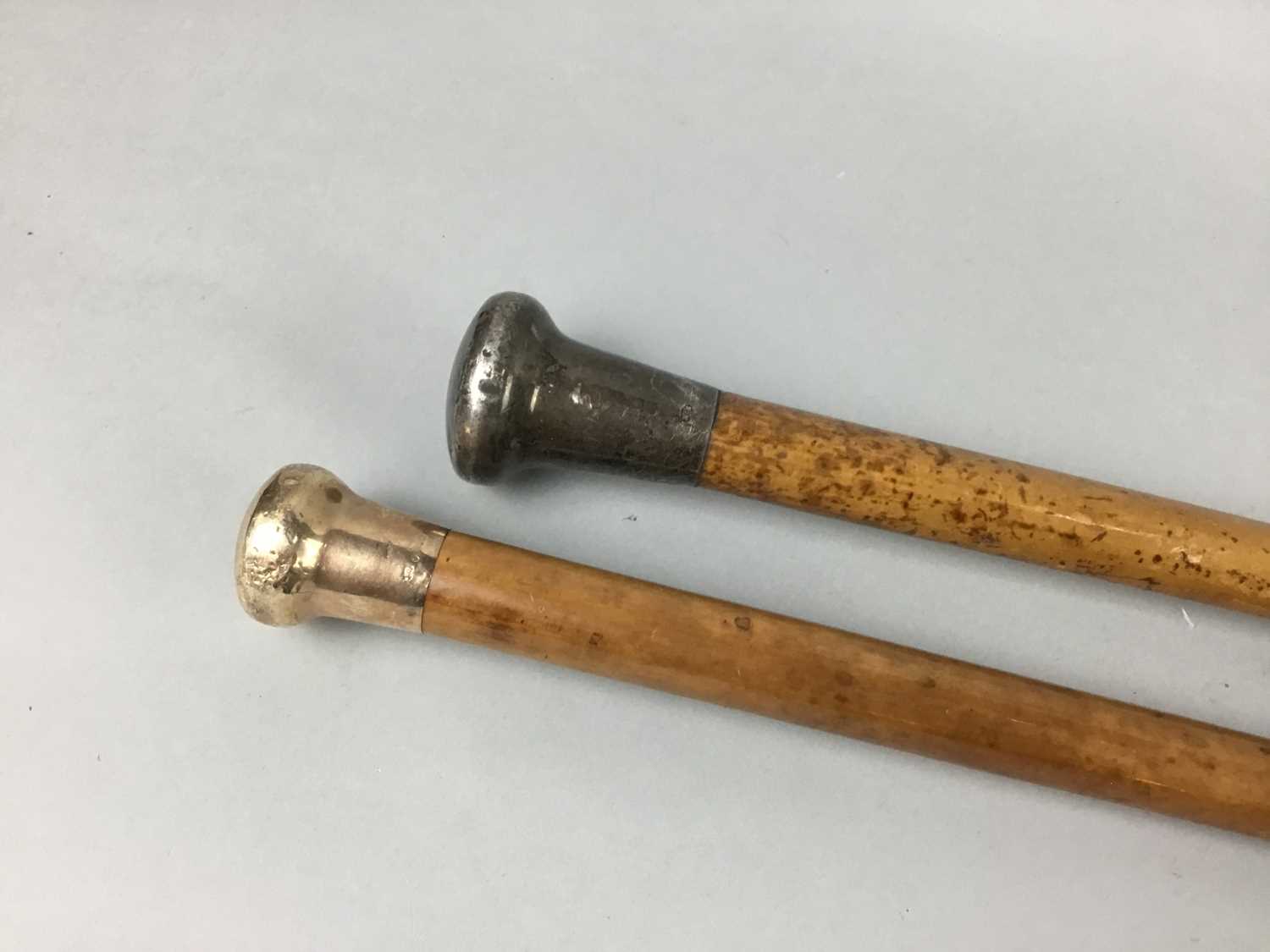Lot 25 - A GOLD AND A SILVER TOPPED CANE