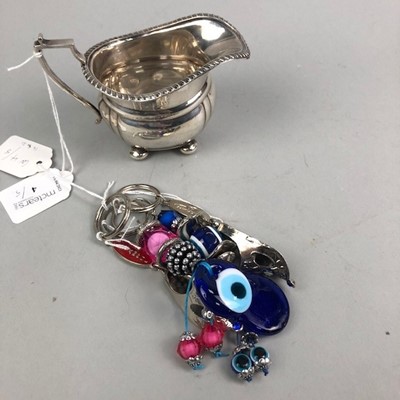 Lot 288 - A PLATED CREAM JUG AND FOUR NOVELTY KEY RINGS