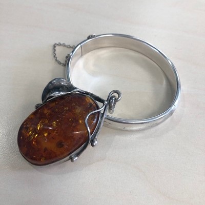 Lot 80 - A CHARLES HORNER SILVER BANGLE AND A BALTIC AMBER PENDANT