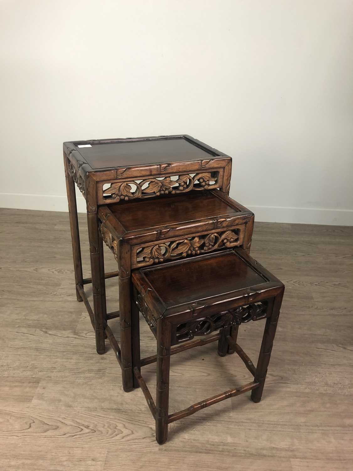 Lot 907 - A 20TH CENTURY CHINESE HARDWOOD NEST OF THREE TABLES