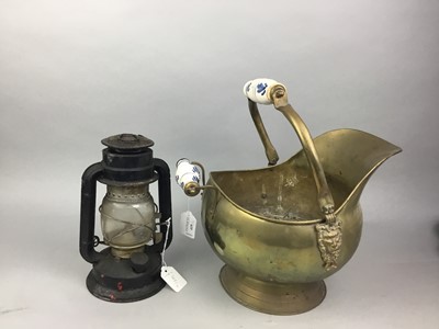 Lot 419 - A BRASS HELMET SHAPED COAL SCUTTLE AND AN OIL LAMP