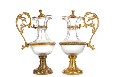 Lot 1729 - A PAIR OF LATE 19TH CENTURY GLASS AND GILTMETAL EWERS