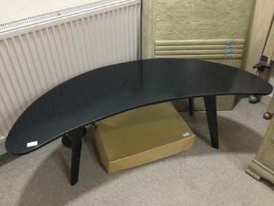 Lot 552 - AN EBONISED CURVED COFFEE TABLE