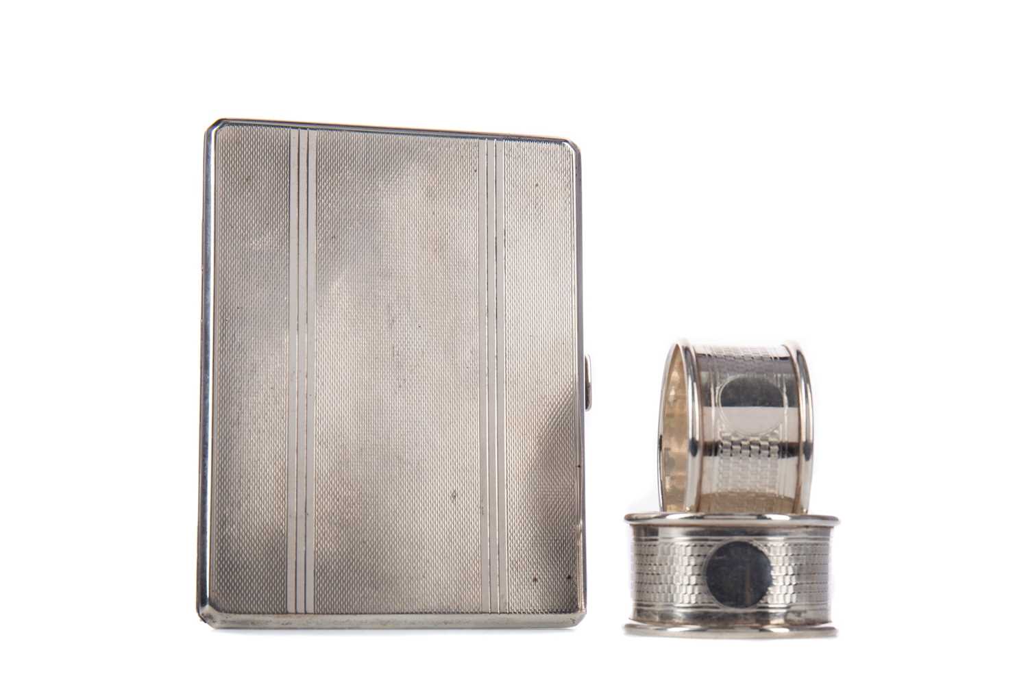 Lot 410 - A GEORGE V SILVER CIGARETTE CASE, ALONG WITH A PAIR OF NAPKIN RINGS