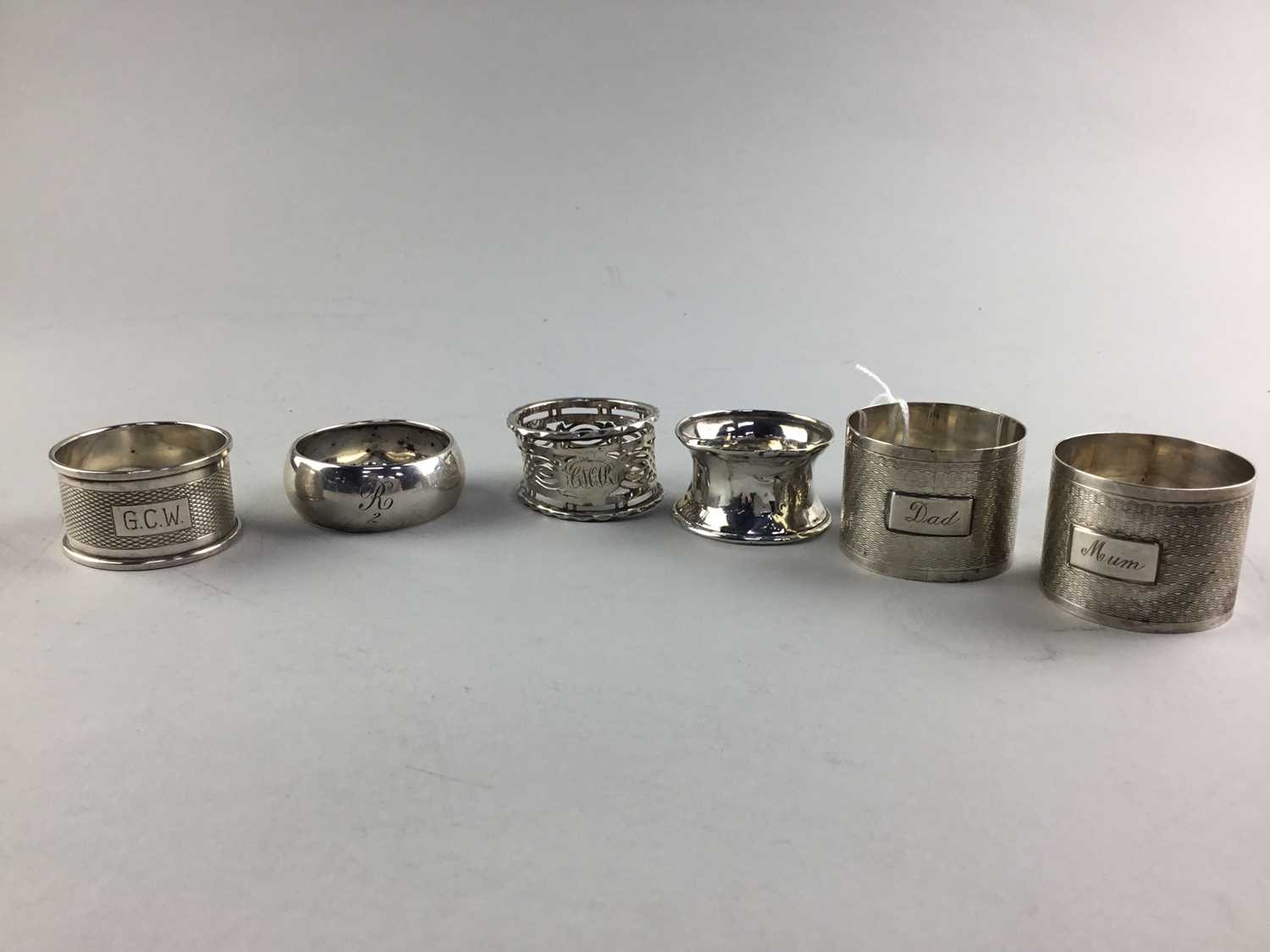 Lot 74 - A PAIR OF EARLY 20TH CENTURY SILVER ENGINE TURNED NAPKIN RINGS AND FOUR OTHER NAPKIN RINGS