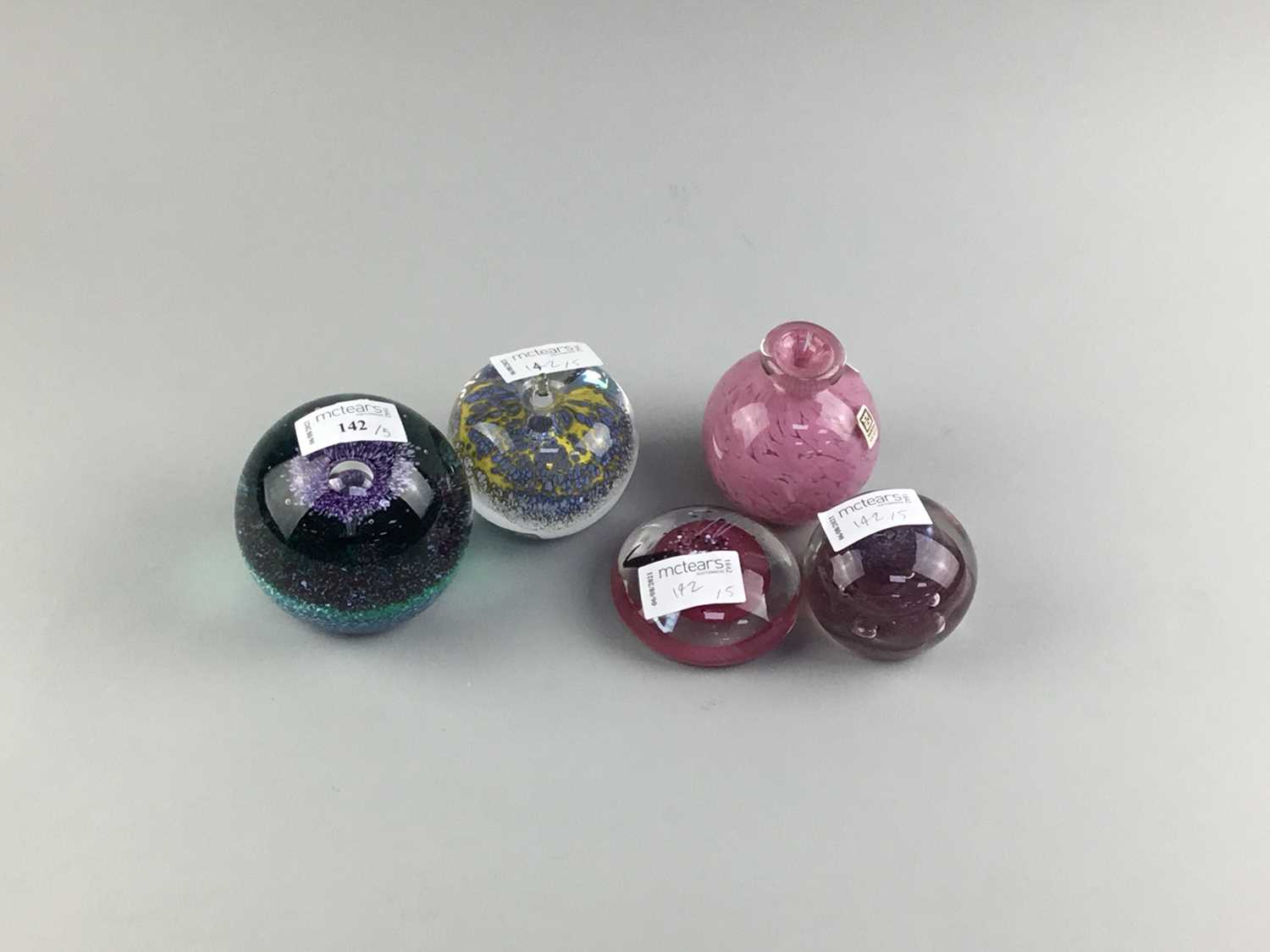 Lot 142 - AN MDINA PINK GLASS VASE AND FOUR GLASS PAPERWEIGHTS
