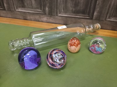 Lot 462 - A LOT OF FOUR GLASS PAPERWEIGHTS AND A GLASS ROLLING PIN