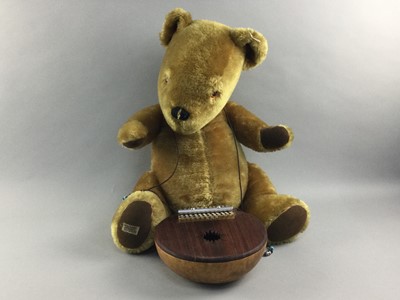 Lot 102 - A VINTAGE MERRYTHOUGHT BLONDE PLUSH TEDDY BEAR AND A WOODEN MUSICAL INSTRUMENT