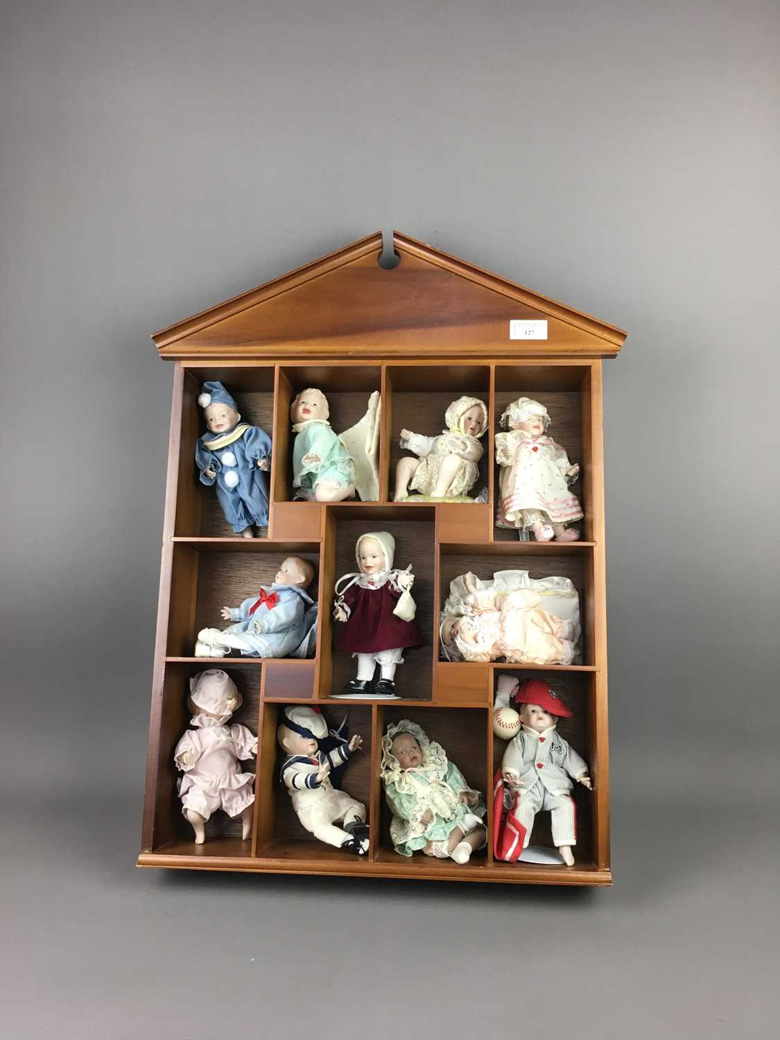 Lot 127 - A COLLECTION OF MINIATURE PORCELAIN DOLLS IN A DISPLAY CABINET