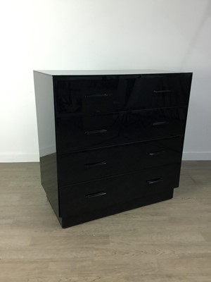 Lot 566 - A BLACK GLASS CHEST OF FOUR DRAWERS