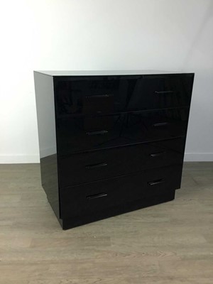 Lot 195 - A BLACK GLASS CHEST OF FOUR DRAWERS