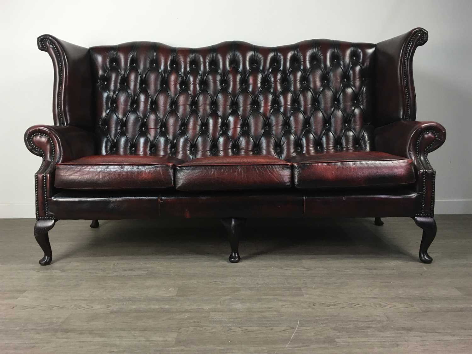 Lot 750 - A THREE-SEATER WINGBACK CHESTERFIELD SETTEE